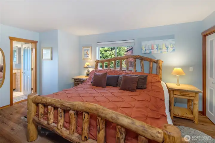 Spacious primary suite featuring warm wood floors, and peaceful natural light—creating a cozy retreat with serene island charm.