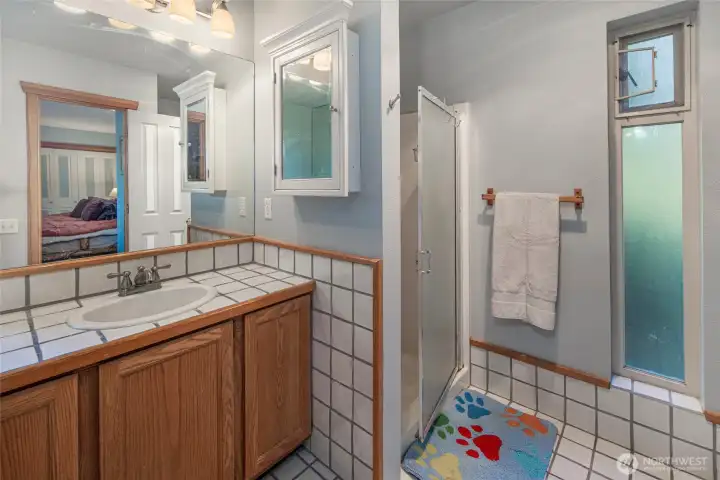 Additional full bath with tiled finishes, walk-in shower, and natural light, thoughtfully designed for comfort and convenience for guests or family.