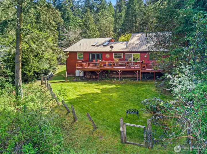 Spacious rear deck extends the living space outdoors, ideal for summer dining, morning coffee, or enjoying the peaceful wooded surroundings.