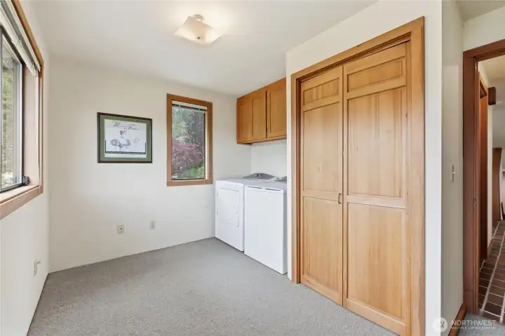 Bright and spacious laundry room with built-in storage and large windows bringing in natural light. Bright and spacious laundry room with built-in storage and large windows bringing in natural light.
