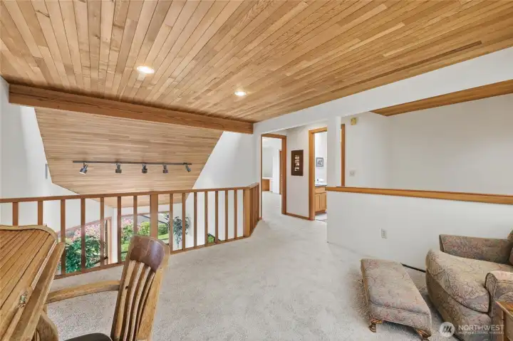 Loft-style space with warm wood ceilings overlooking the living room below. Loft-style space with warm wood ceilings overlooking the living room below.