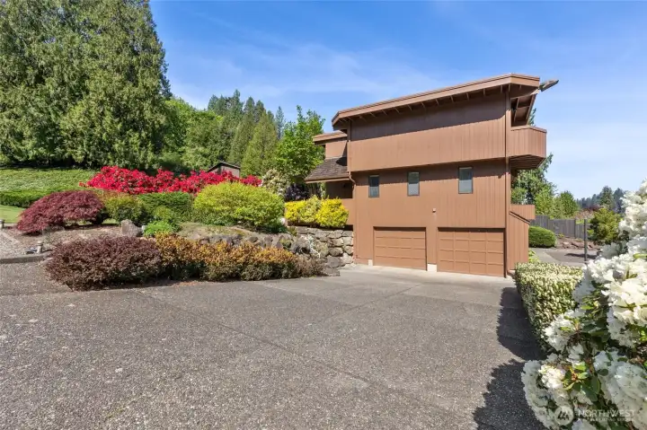 The driveway and garage with a beautifully landscaped yard The driveway and garage with a beautifully landscaped yard