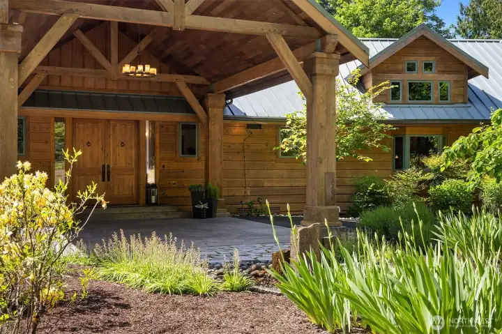 A gurgling fountain, lush landscape, solid wood beam porte cochere entry & parking plentiful to delight any host