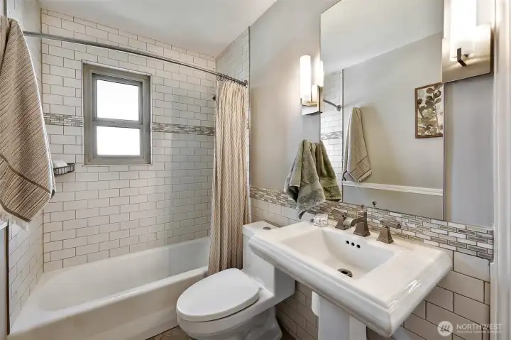 Primary bathroom with ceramic tile floor & custom tile shower surround.