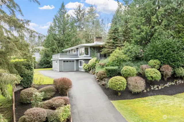 Tucked away from the street, this home offers a sense of privacy surrounded by lush landscaping and mature trees. The long driveway and thoughtfully designed greenery create a secluded retreat while still being conveniently located to Downtown Bellevue.