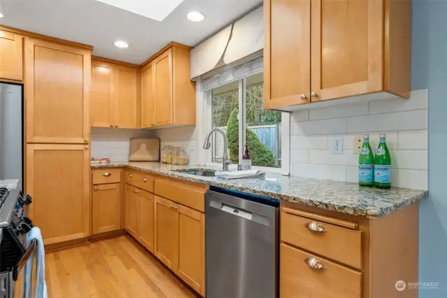 The kitchen sink overlooks the backyard, offering a pleasant view while preparing meals. Sleek subway tile adds a  timeless charm.