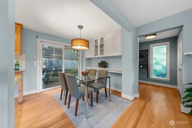 The dining area includes built-in cabinetry for extra storage and a stylish light fixture for added charm. Sliding glass doors open to the patio, making outdoor dining and entertaining effortless.