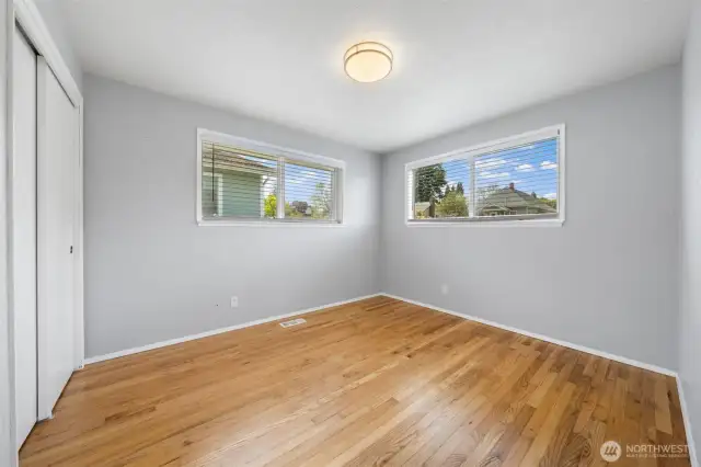 Bedroom with lots of natural light and beautiful hardwood floors.