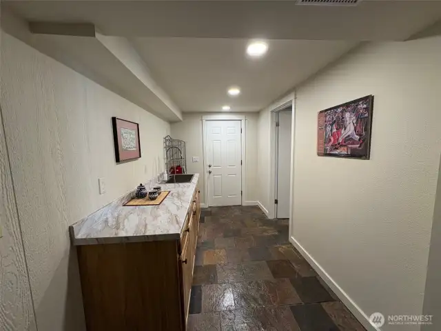 Downstairs entry to a potential kitchen with cabinets and sink already installed