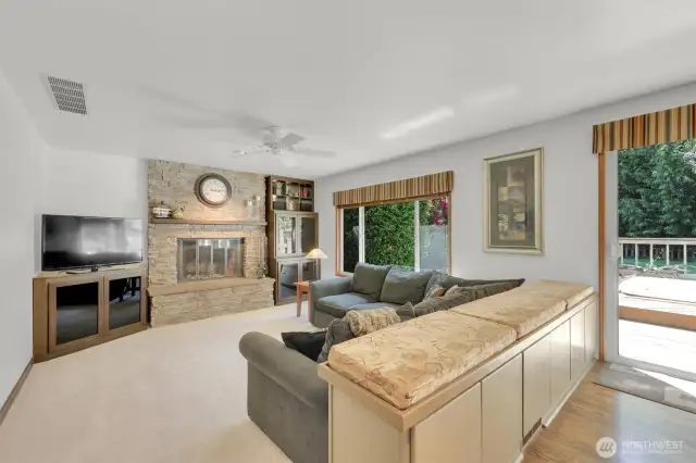 Additional bench seating with built-in storage backing to family room with beautiful updated stone fireplace surround and built-ins.