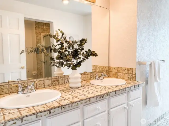 You'll love the thoughtful design of the hallway bathroom with dual sinks, spacious walk-in shower, and direct patio access - no wet feet tracking through your main living areas