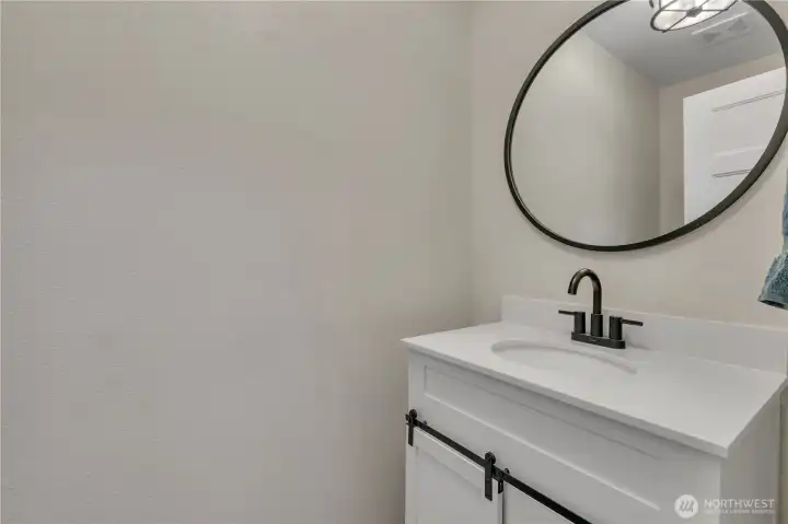 Half bathroom on the main floor with updated vanity and stylish black fixtures.