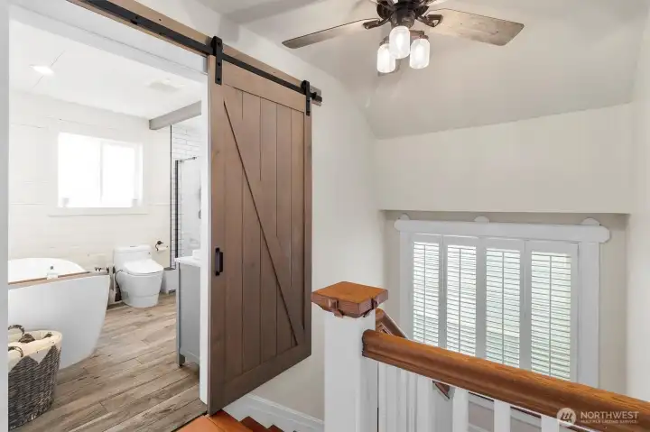 Light-filled landing at the top of the stairs, connecting bedrooms and adding to the home’s classic 1920s character.