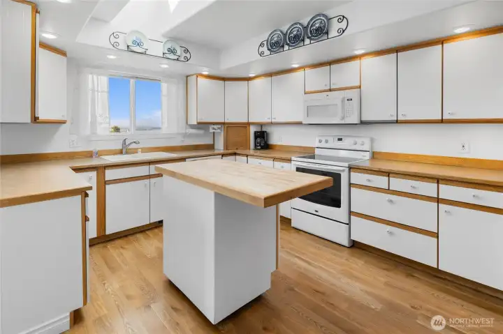 Kitchen is light and bright and lots of counter space including a butcher block island, skylight brings in more light!