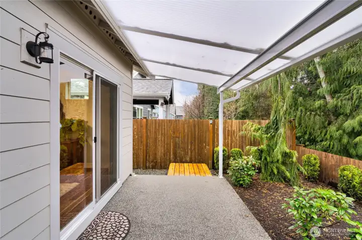Covered patio overlooking landscaped yard.  Owner installed this very cool covered solid awning that lets so much light into the house.  The patio extends the entire back side of the house (upgrade when built).