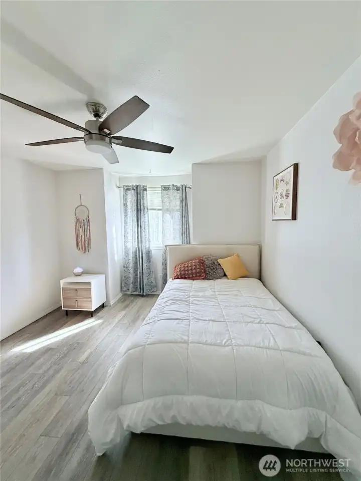 The primary bedroom has its own bathroom and ceiling fan.