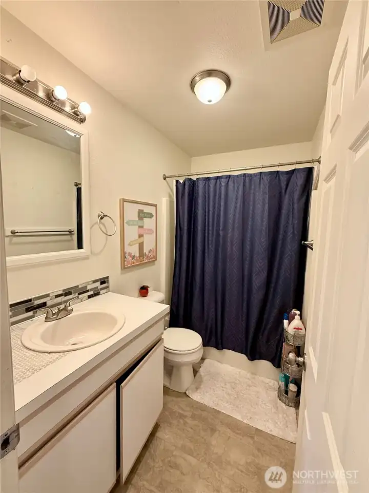 Hallway bathroom has a shower/tub combo.