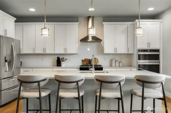 Large kitchen quartz island. Double oven, gas range and SS hood-vent.