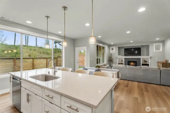 Large kitchen quartz island. Beautiful wood wrapped windows with scenic views