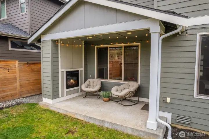 Hello summer living! Outdoor patio with gas fireplace. Looking out to nature.