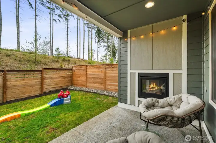 Hello summer living! Outdoor patio with gas fireplace. Looking out to nature.