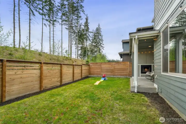 Hello summer living! Outdoor patio with gas fireplace. Looking out to nature.