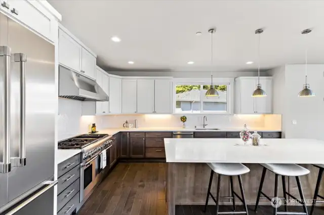 Stainless Thermador appliances and quartz slab countertops complement this kitchen.