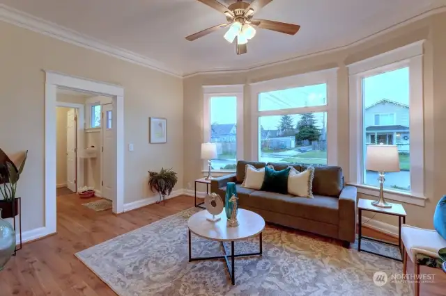 Living Room With Intricate Crown Moldings & Wood Wrapped Windows.