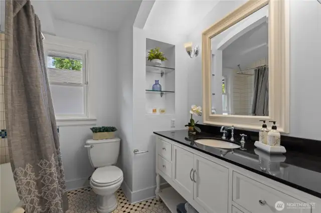 Full Hall Bath with decorative tiled floor, old fashioned tub and modern upgrades.