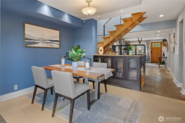 Dining room opens to modern steel cable and wood stairs.