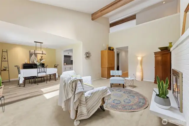 From the diing room, you step down into the living room. The exposed wood beams draw your eye to the upstairs loft.