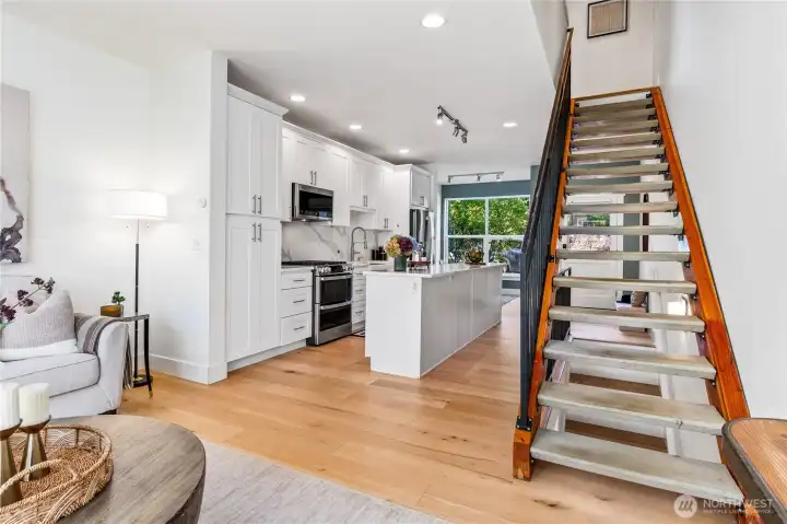 The sleek, modern staircase connects the front and back of the home, from entry to living room. Large windows on both sides bring in so much natural light!
