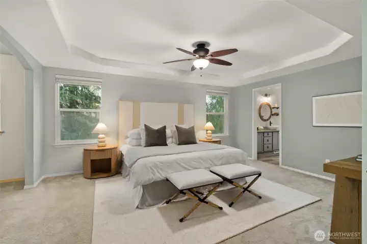 The primary bedroom is a true sanctuary that is located on the quiet forested side of the house.  Tray ceiling, symmetrical windows on either side of the bed, and plenty of room to spare for dressers, tables and more.