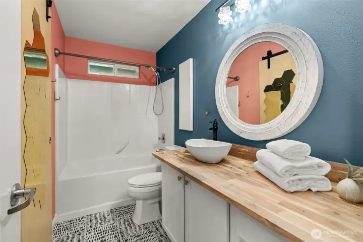 Upstairs full bathroom that also offers linen storage, vessel sink, custom countertop and lighting.