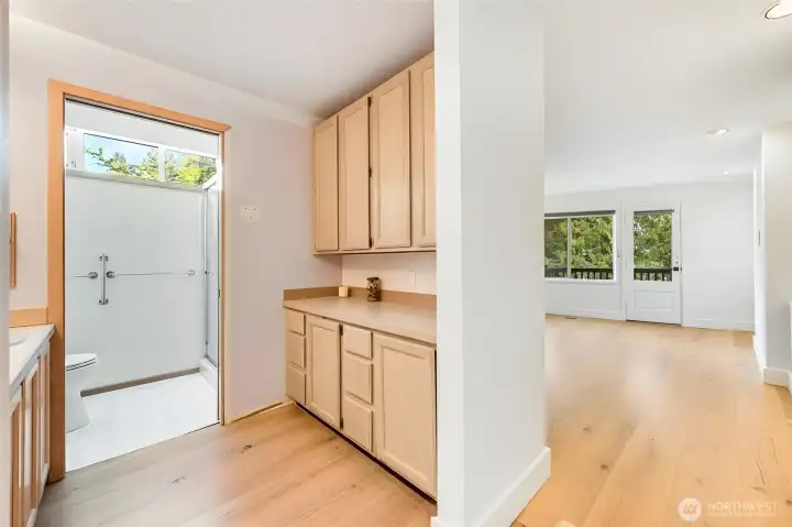 The primary bathroom is the only area that has not been remodeled in this house. A row of closet on the RH side, and there's plentiful cabinet storage. A private toilet and shower room is on the left-side background.