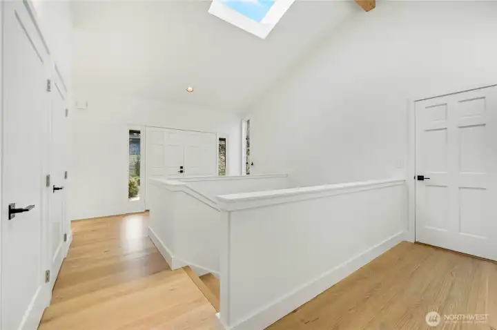 The front entry has three large closets, French doors to the main entrance, vaulted ceiling, new skylight, stairs to the daylight basement, and the door on the right leads to the three-car garage.