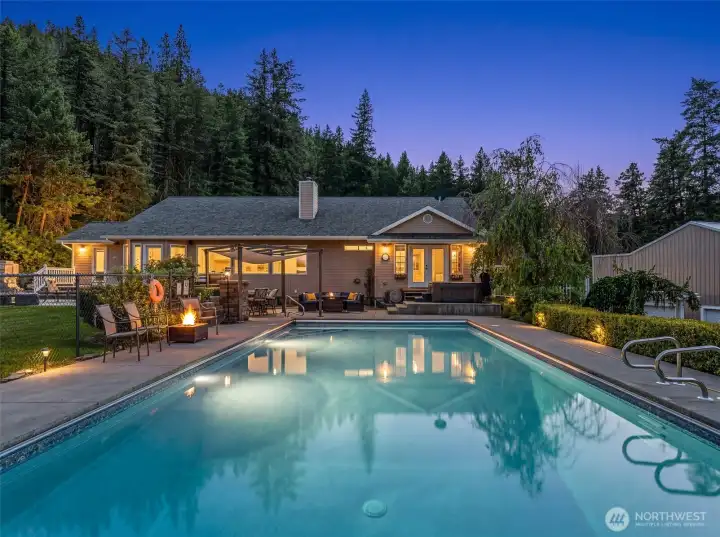 Private Cashmere retreat featuring a heated in-ground pool, spacious patio, and hot tub, all set against a backdrop of mature pines and scenic mountain views. Fully usable grounds offer a perfect blend of recreation, relaxation, and privacy. Private Cashmere retreat featuring a heated in-ground pool, spacious patio, and hot tub, all set against a backdrop of mature pines and scenic mountain views. Fully usable grounds offer a perfect blend of recreation, relaxation, and privacy.