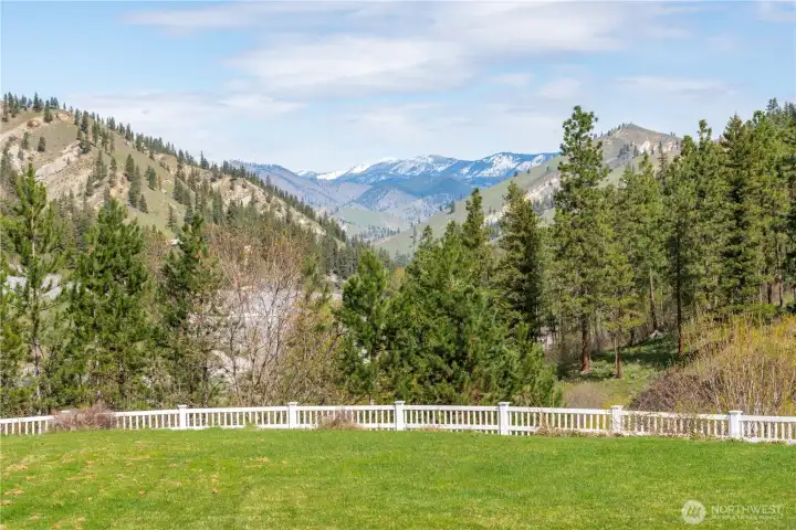 Level, usable lawn with fenced boundary, capturing wide-open mountain views and a serene natural backdrop.