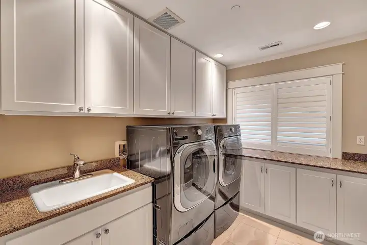 Laundry with new washer and dryer and cabinets with pullouts