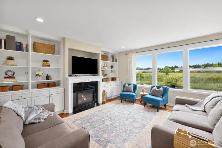 Family room features cozy gas firelace, built in shelving and large picture windows to see the serene water and pasture views!