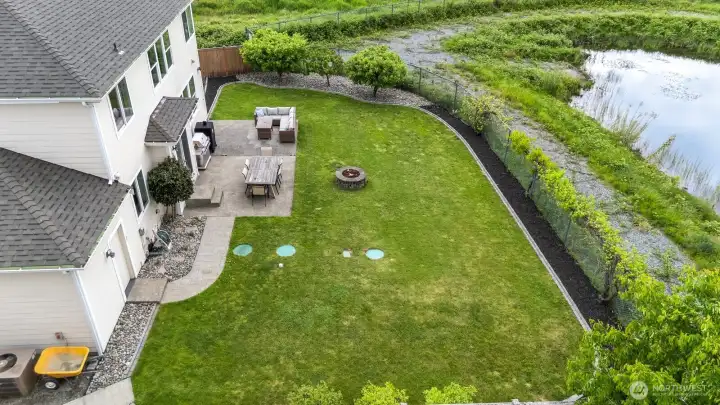 Fully fenced backyard with patio and built in fire pit.