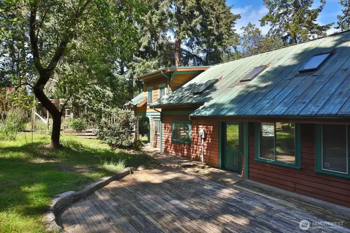 A back deck too with a beautiful madrone and an area to garden. Enjoy the blooms of the rhodies.