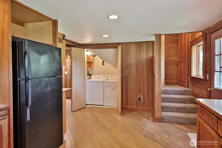Looking back towards the main entry way (to the left of the closet with the washer and dryer). Stairs to the right are to the upper level Primary Suite. Door along right edge of photo leads to the covered portion of your waterside deck.