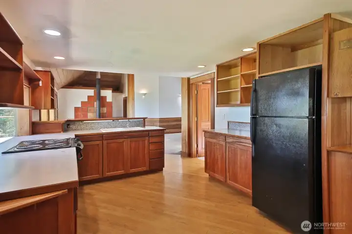 With your back to the stairs, you are now looking out towards the living room. The doorway beyond the counter (before stepping into the living room) is one of the two main level bedrooms. Doors are solid wood!