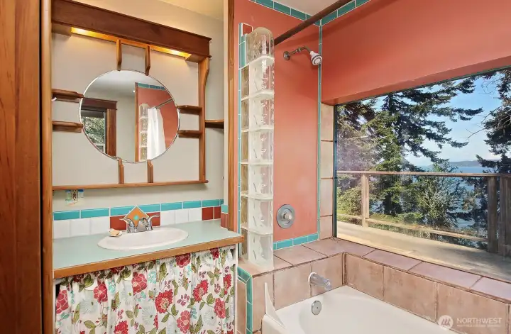 This is the main level full bath. There is another sink on the other side of the bathtub (beyond the right edge of this photo). A tub with a view! There are a lot of thoughtful built-ins in here too!