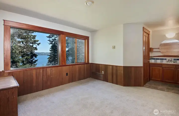 This is what you see as you come up the stairs. This entire upper level is the Primary Suite. There is additional closet/storage space up here. Generous windows maximize your views. And, of course, the beauty of wood continues upstairs. Door to the left of the sink is to the bathroom.