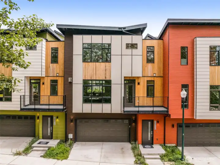 Striking modern architecture showcasing clean geometric lines, a sophisticated dark siding palette, and warm wood accents.