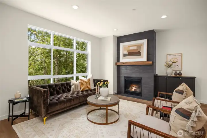 Another look at the spacious living area, anchored by a sleek modern fireplace and large windows framing serene views.