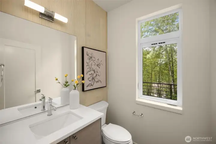 Main-level powder room featuring an upscale floating vanity, modern plumbing fixtures, and crisp, clean finishes.