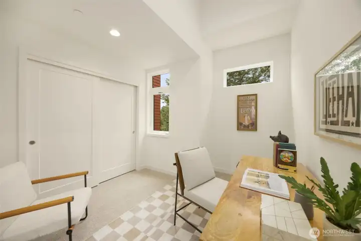 Generously sized bedroom or home office option featuring plush carpeting, clean contemporary lines, and bright windows.